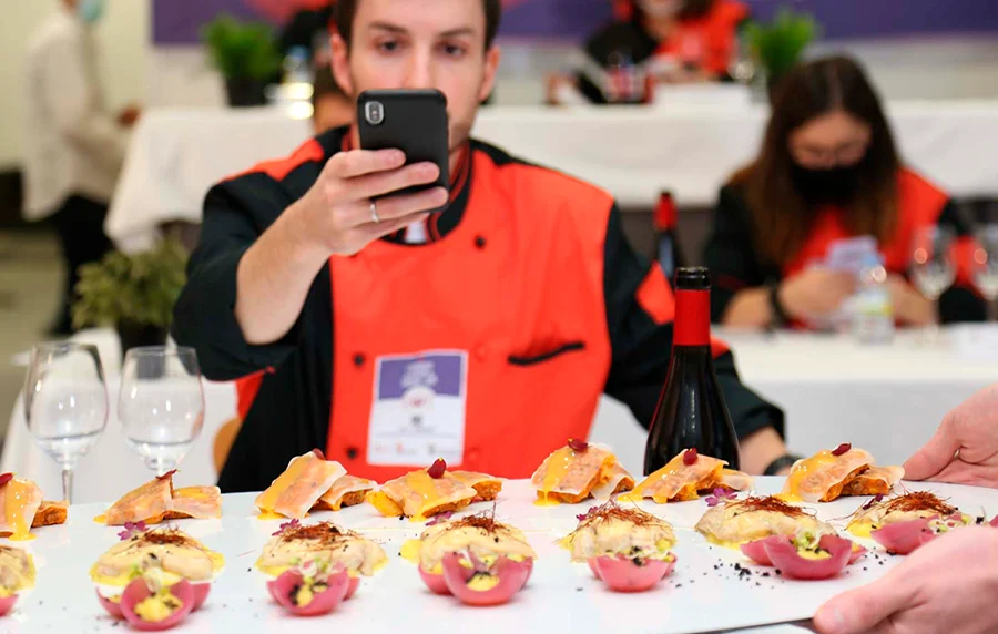 jurado fotografiando platos durante campeonato de cocina y reposteria de cyl